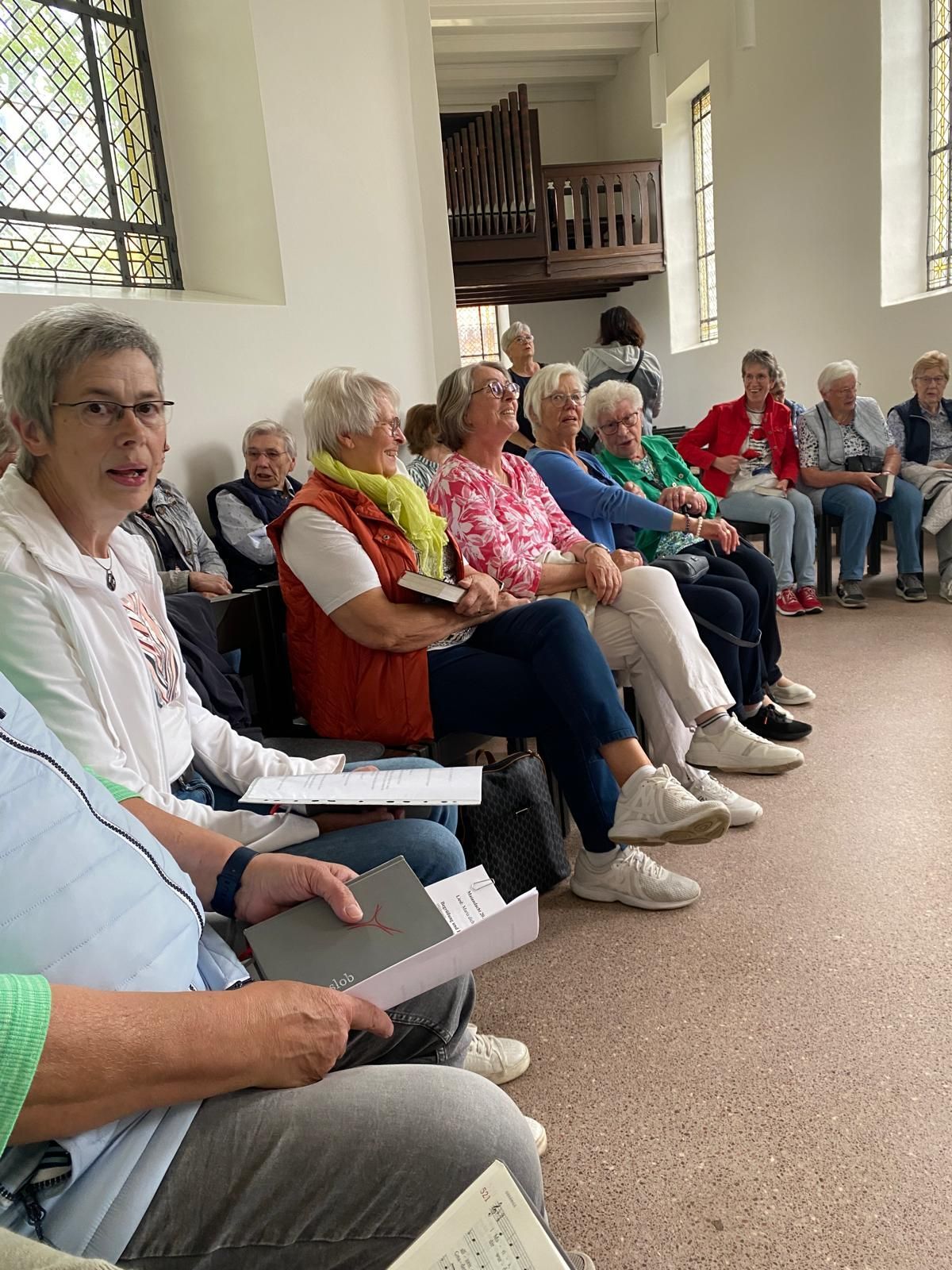 Eine Gruppe von Menschen sitzt in einem Raum im Kreis.