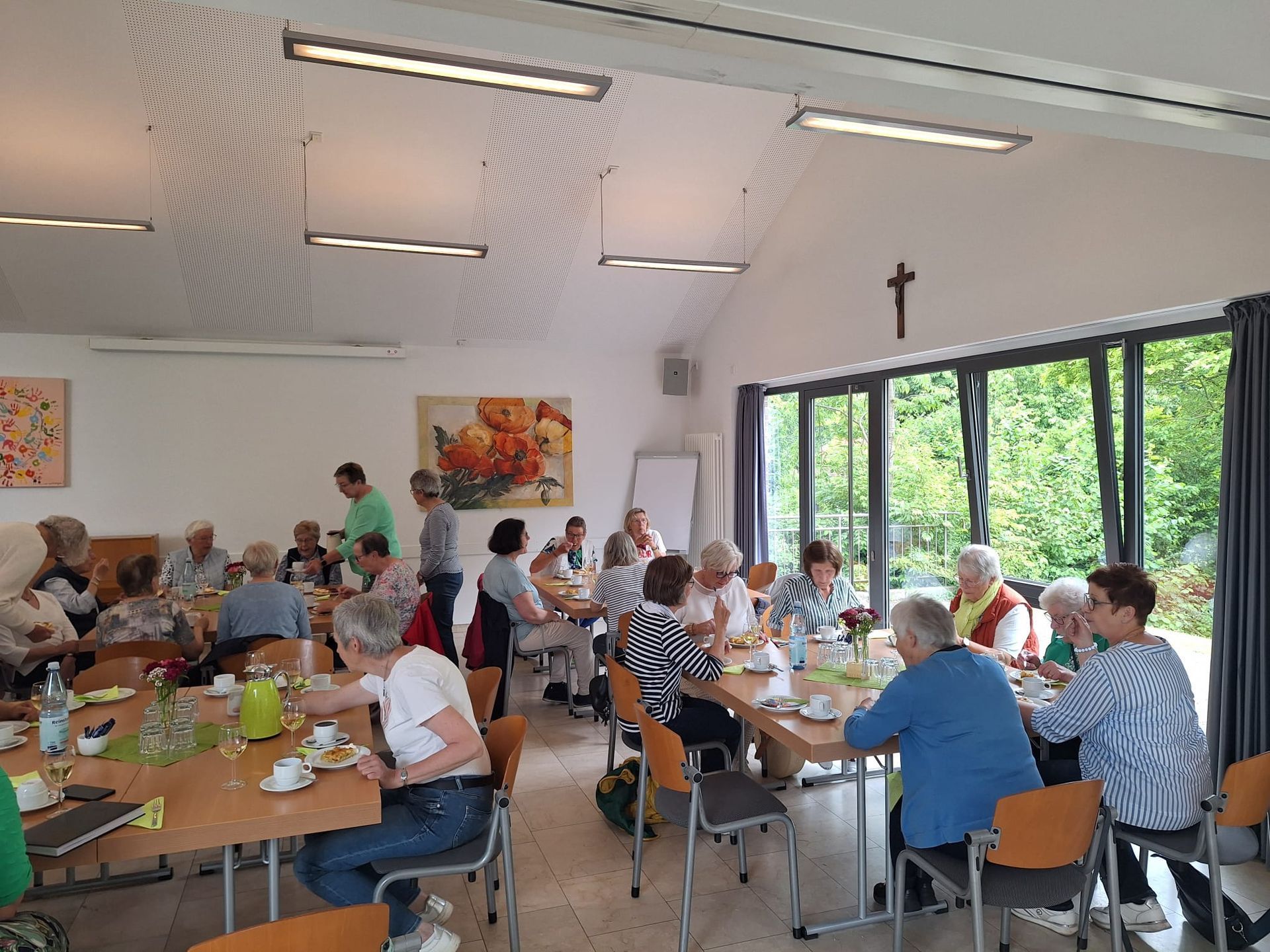 Eine Gruppe von Menschen sitzt in einem Raum an Tischen.