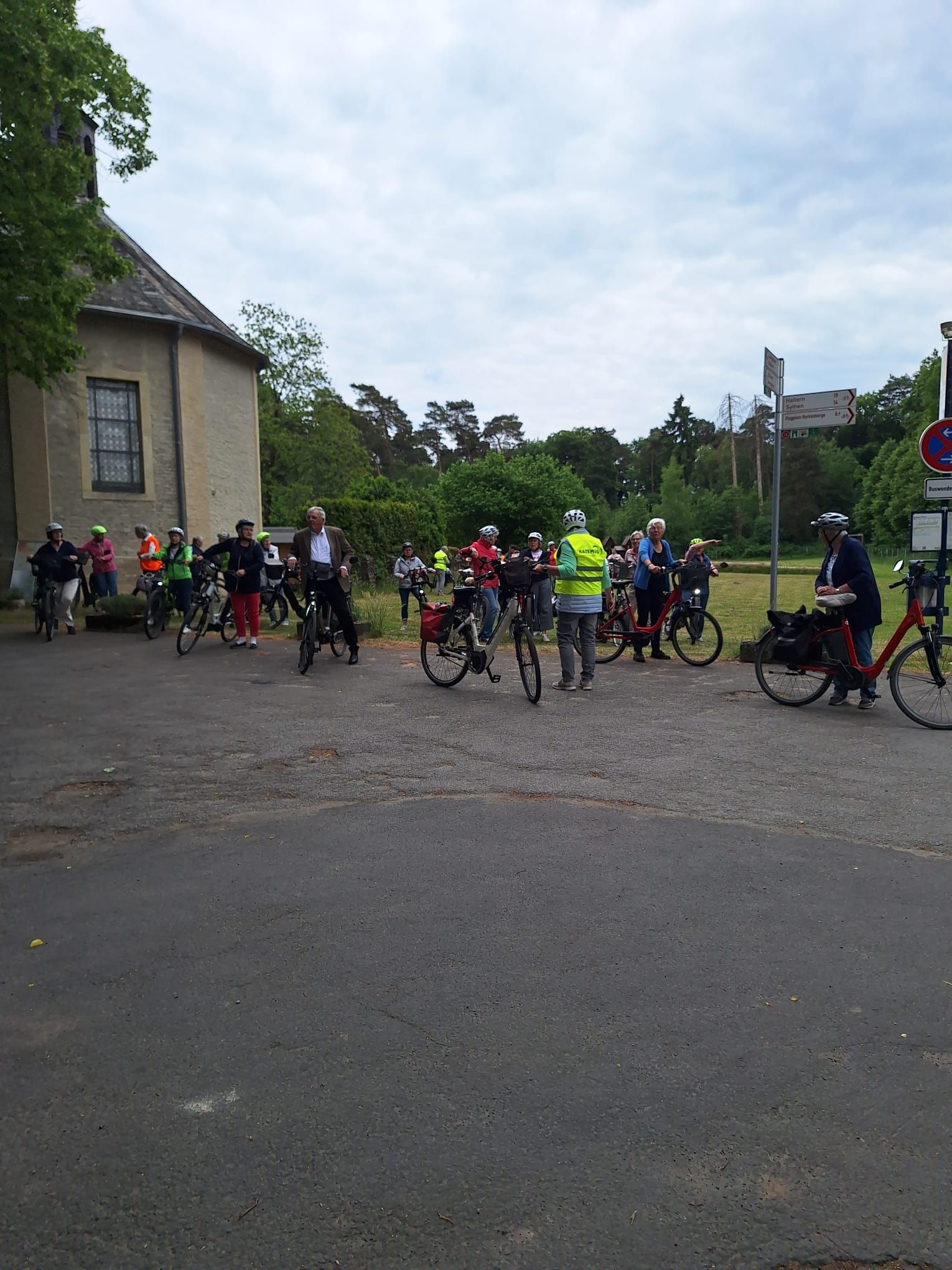Eine Gruppe von Menschen fährt auf einem Parkplatz Fahrrad.