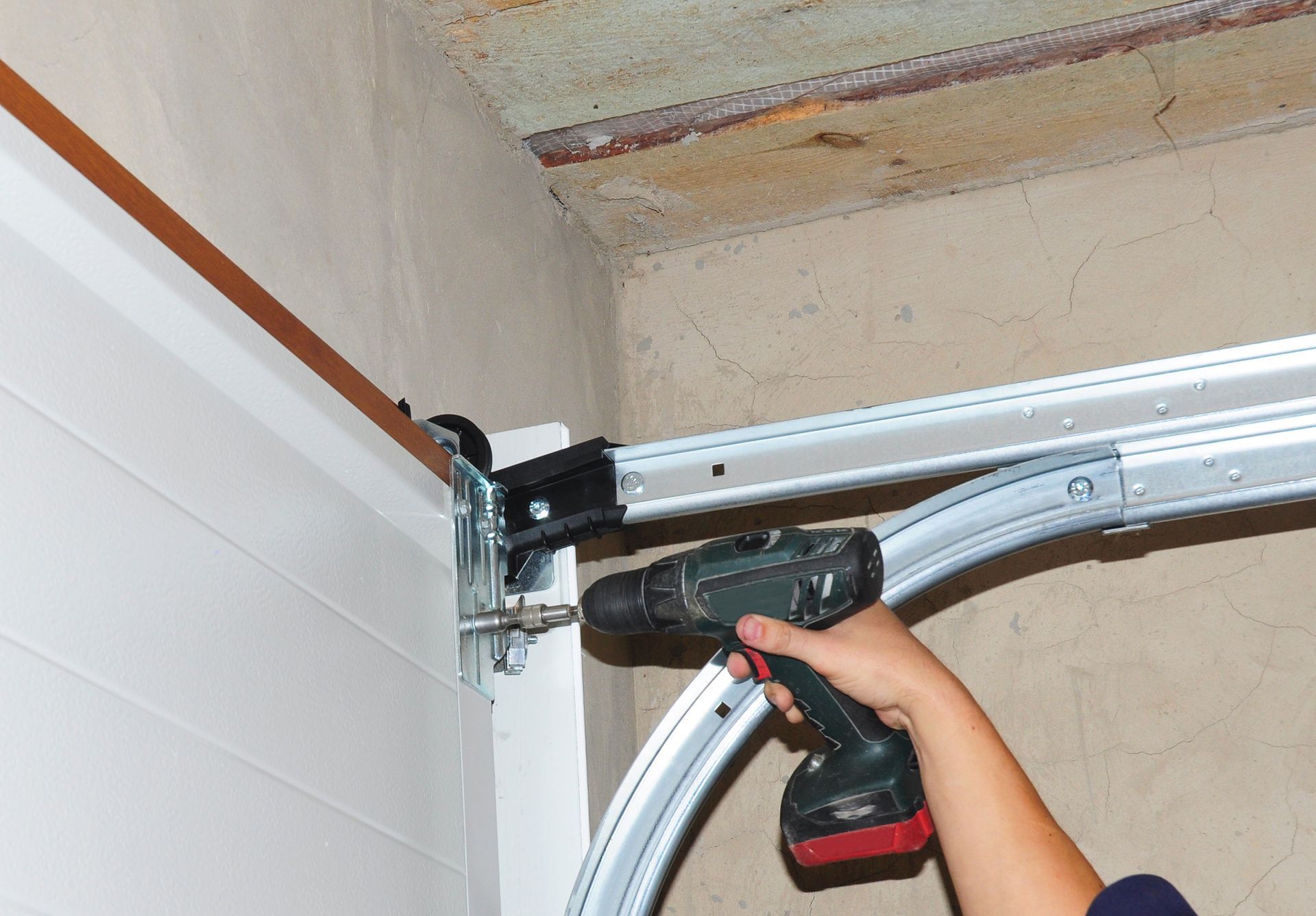 Close-up of a man installing a garage door.