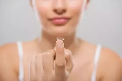 Contact lens balanced on the tip of a lady's finger