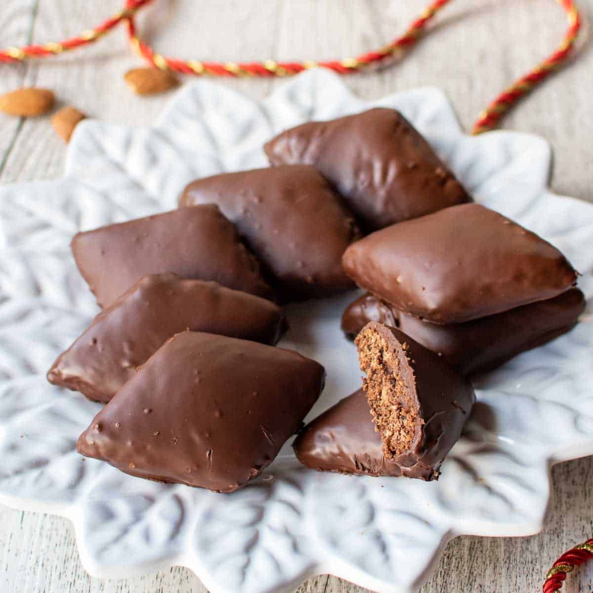 Un uomo in camice nero da chef sorride, tenendo in mano una grande palla bianca, vicino a una scatola. Bar con bottiglie.