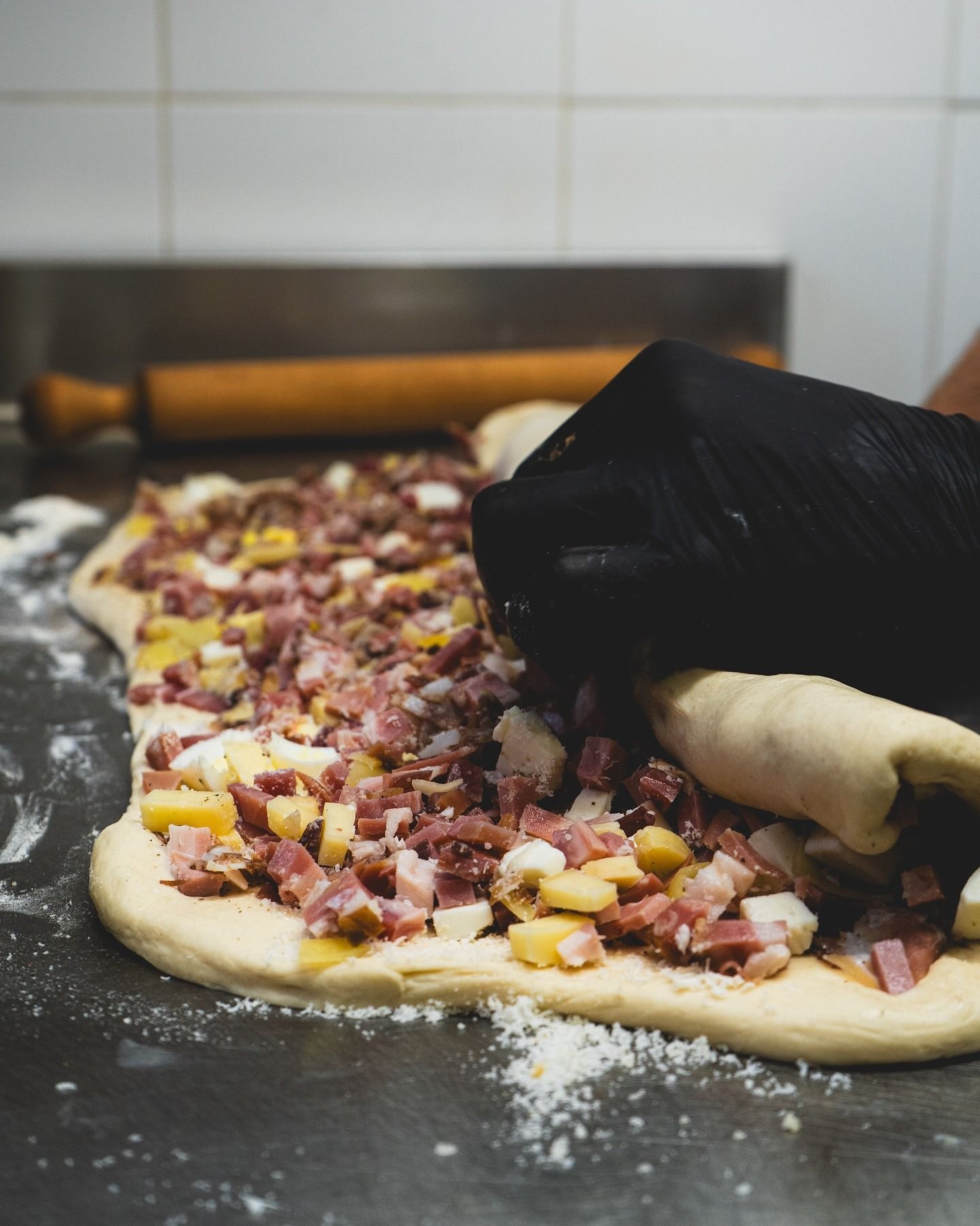 Pane pasquale a forma di ciambella, con quattro uova incastonate nell'impasto, su un piatto di legno.