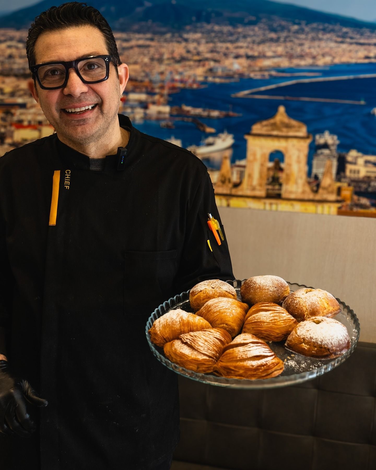 Persona che tiene in mano un barattolo di vetro contenente frutta conservata, probabilmente pesche, in un ambiente illuminato.