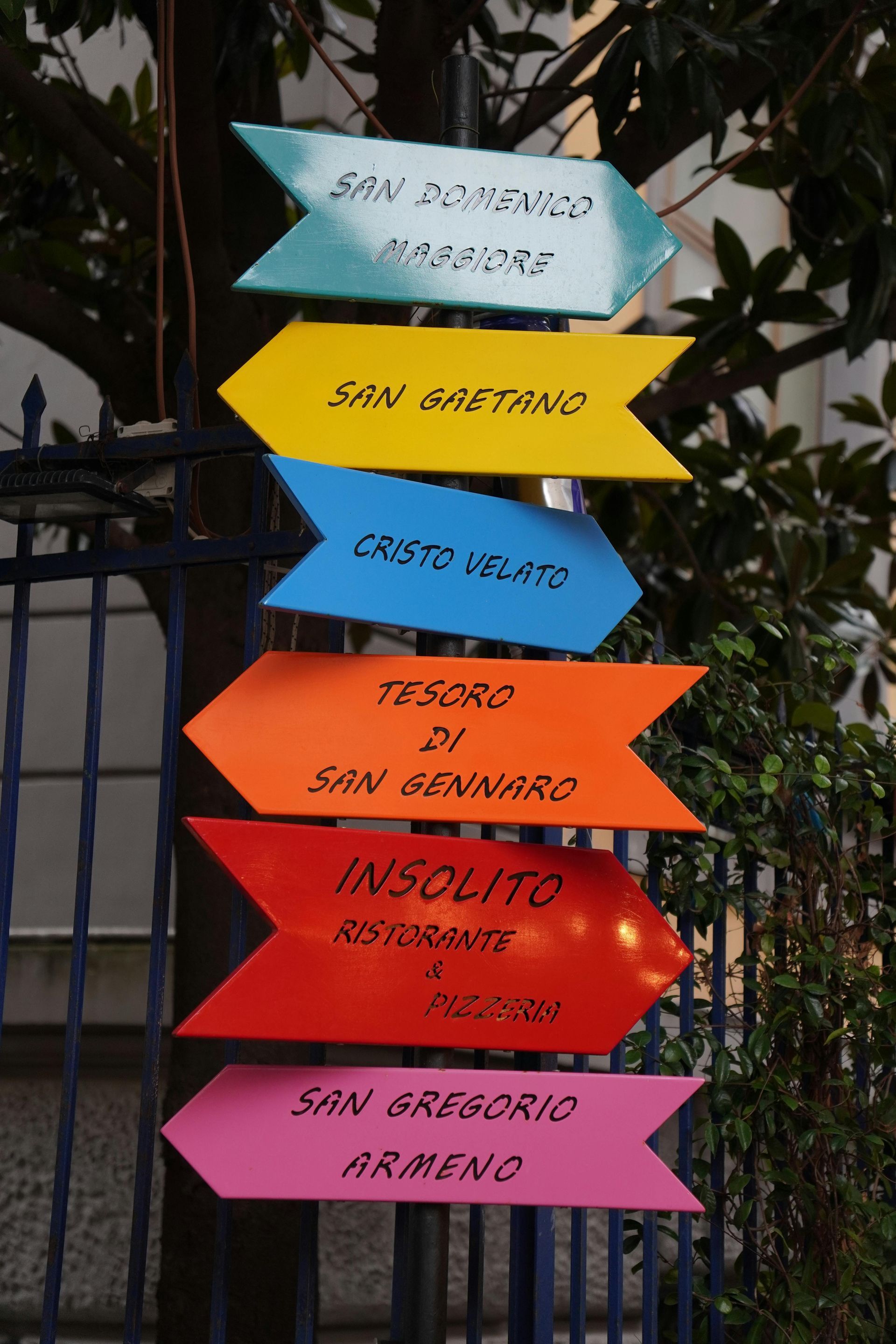 Piccole pizze su un piatto, un bicchiere di vino, un giornale, su un tavolo di legno chiaro.