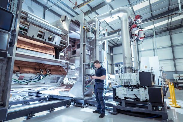 Technician inspecting CNC machinery as part of precision machine shop services in a modern facility.