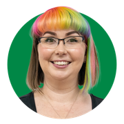 A woman with glasses and rainbow hair is smiling in a green circle