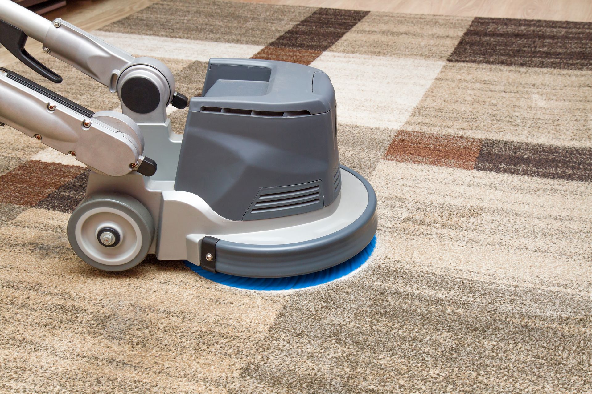 A vacuum cleaner is being used on a light beige carpet, removing dirt and leaving clean lines.