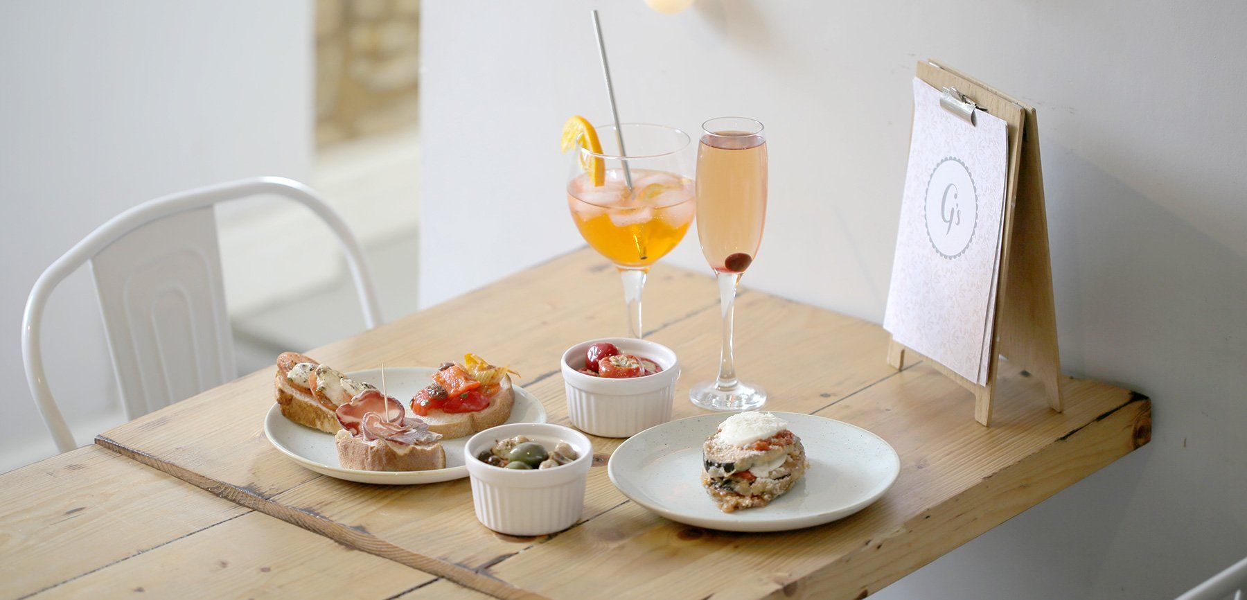 A wooden table topped with plates of food and drinks.