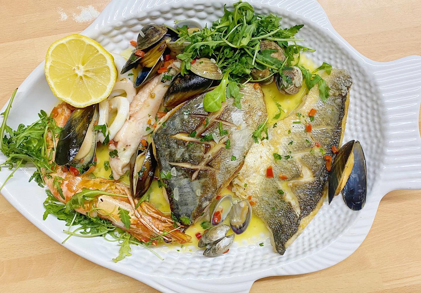 A fish shaped plate with a lemon slice on top