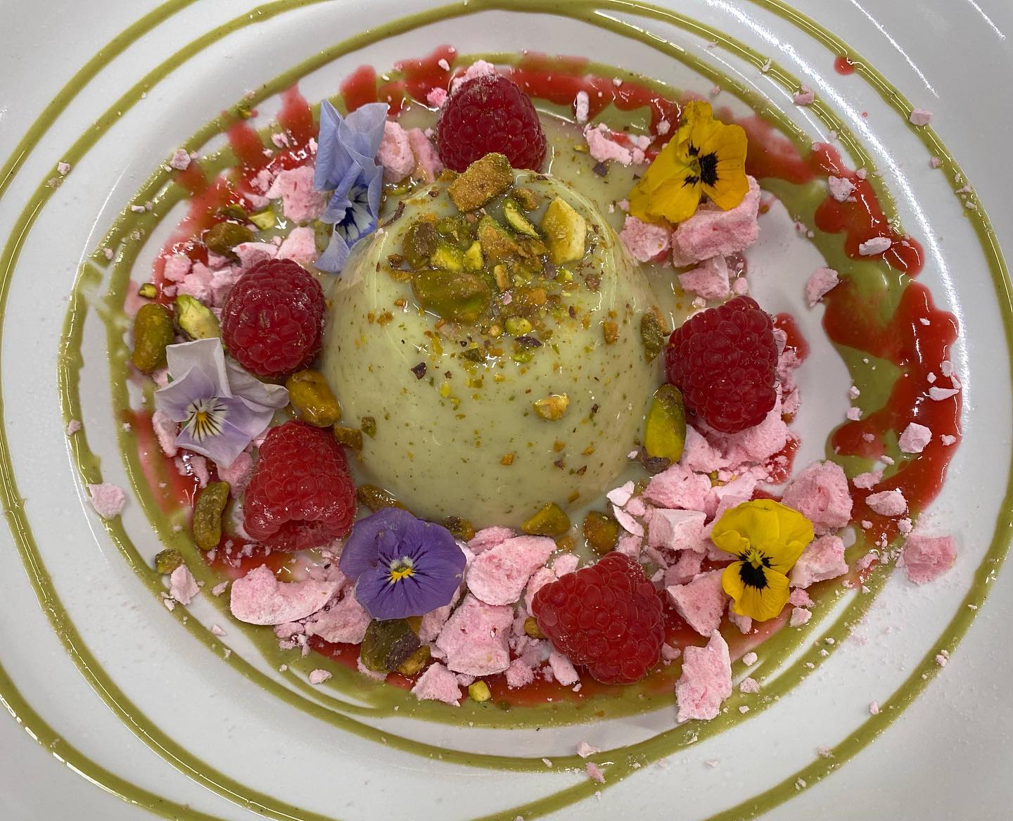 A white plate topped with a dessert with flowers on it
