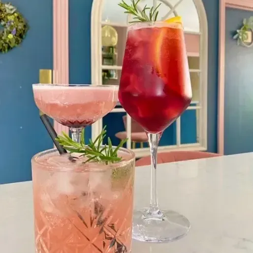 Two cocktails are sitting on a table.