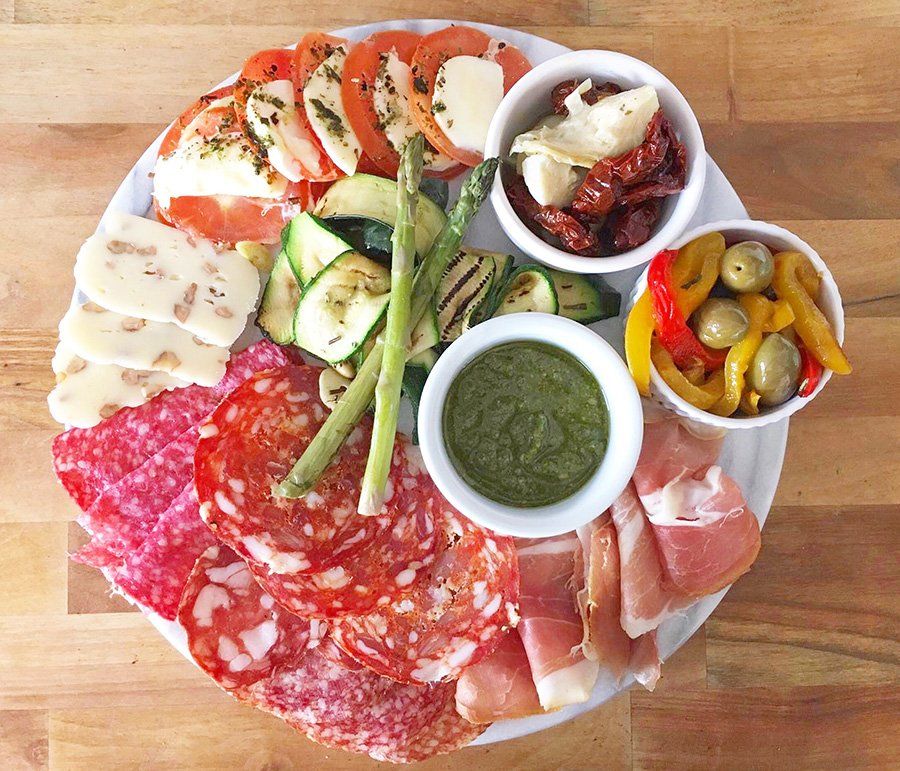A plate of meats and vegetables on a wooden table