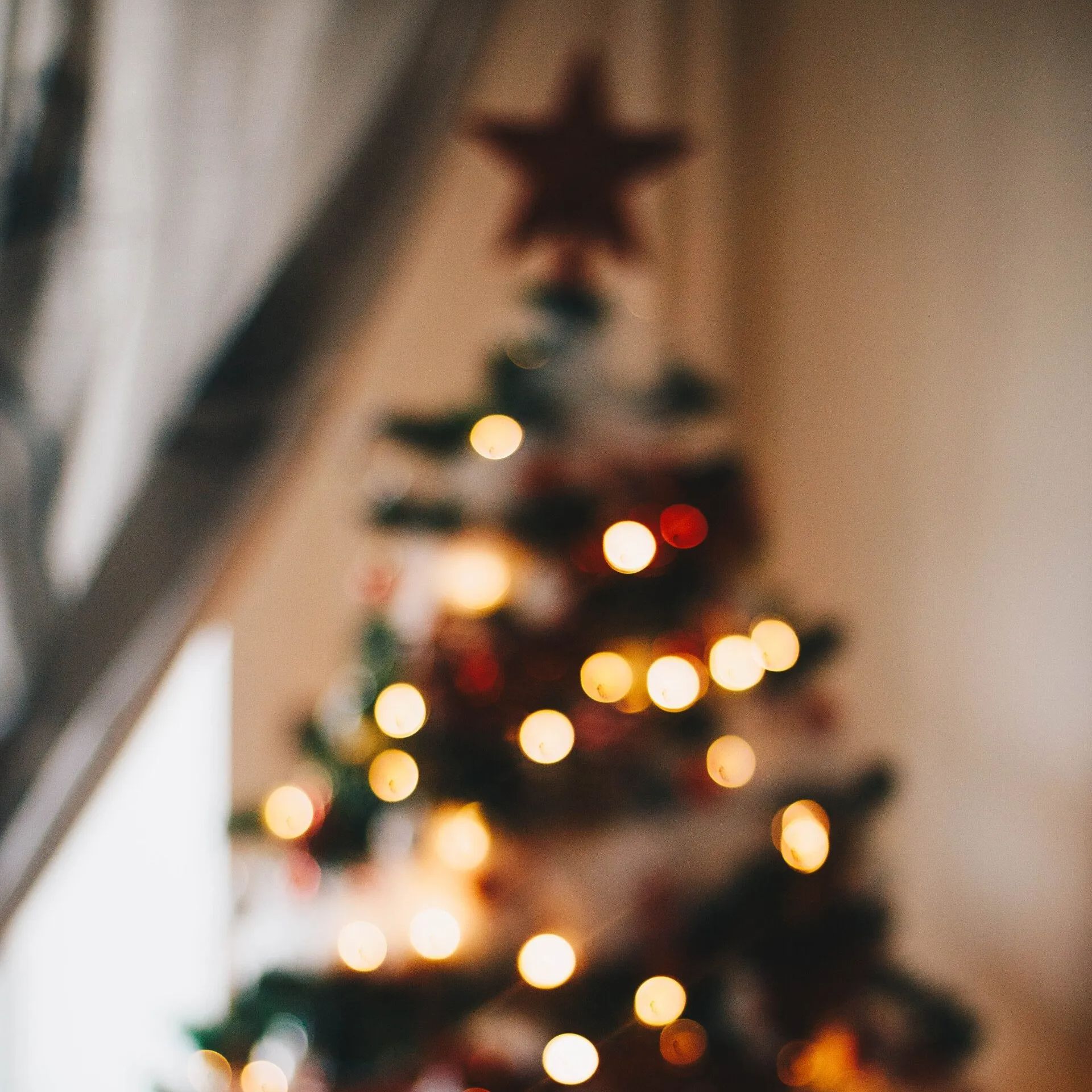 A blurry picture of a christmas tree with lights and a star on top.