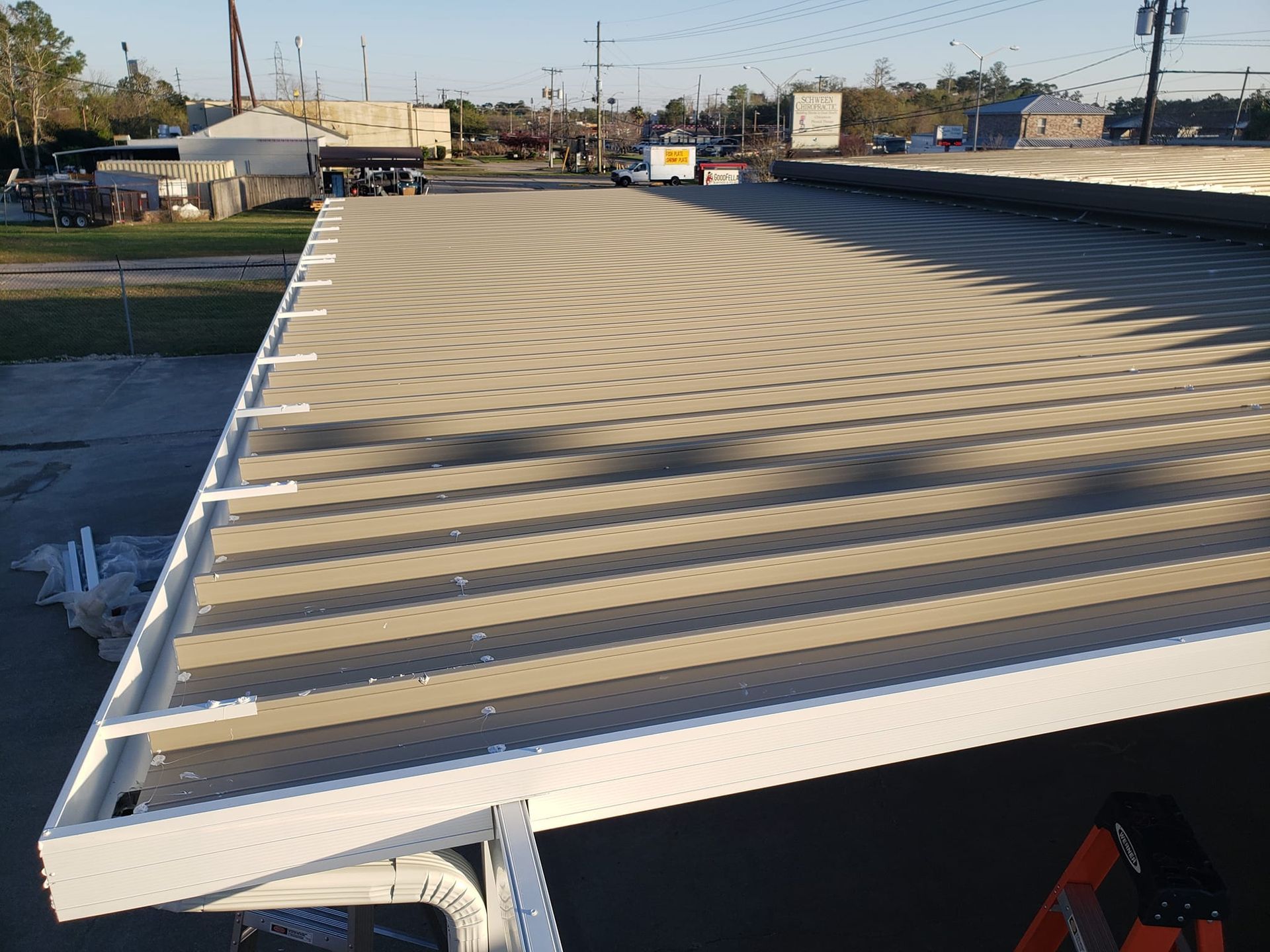 Flatbed trailer with a light tan surface and white border, outdoors.