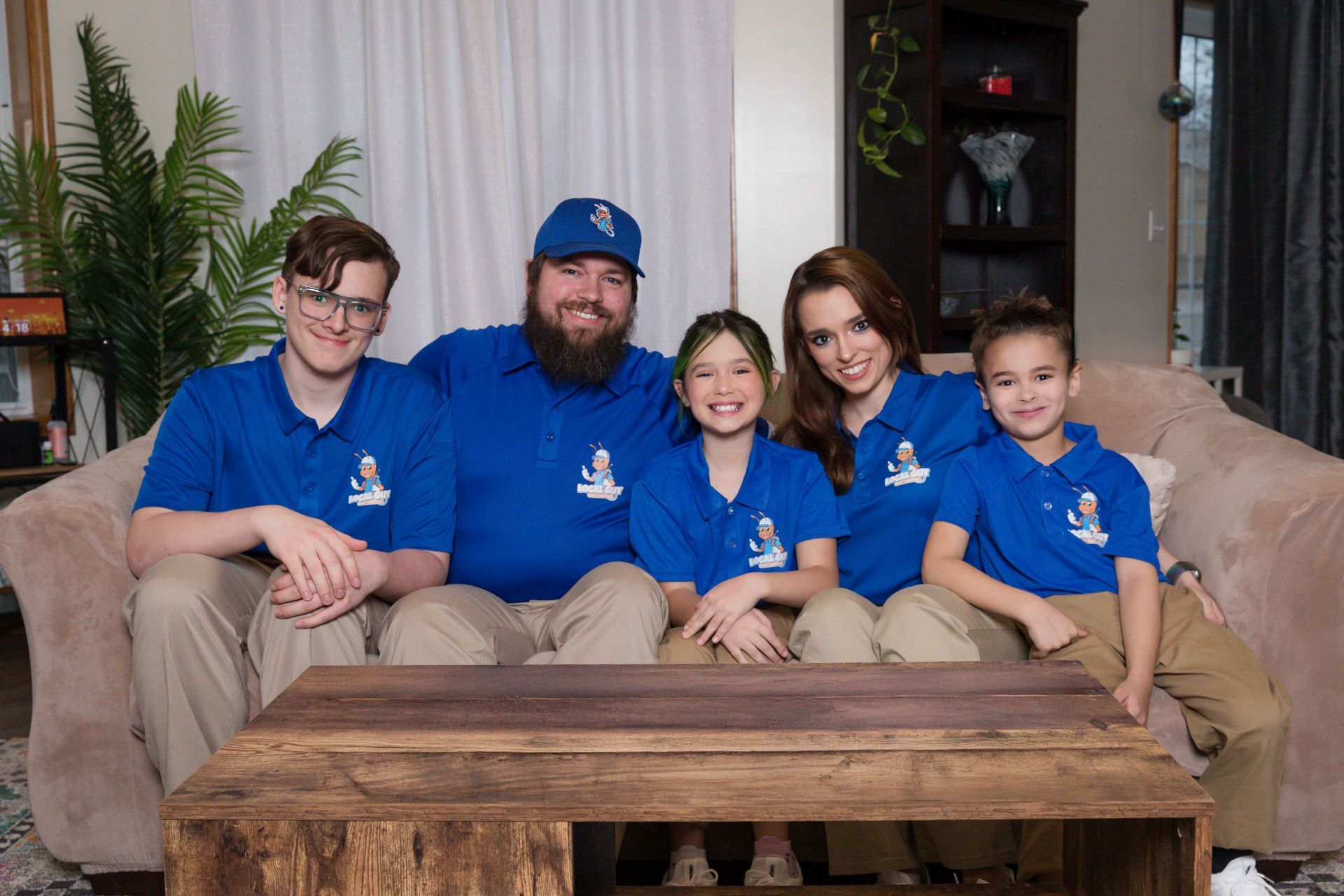 A family is posing for a picture while sitting on a couch.