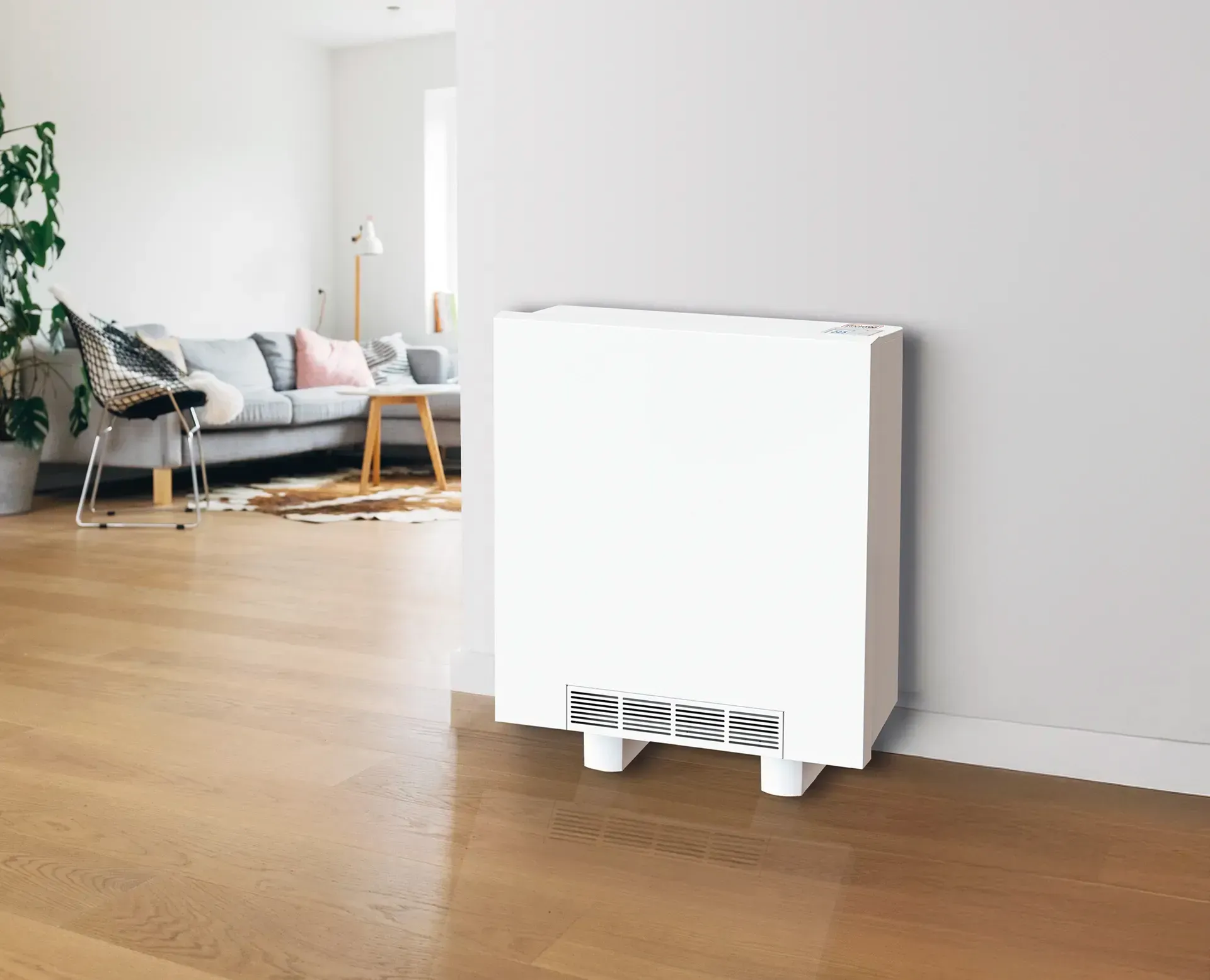 White storage heater unit against a gray wall in a modern living room with hardwood floors.