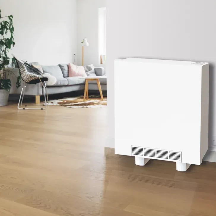 White storage heater unit against a gray wall in a modern living room with hardwood floors.