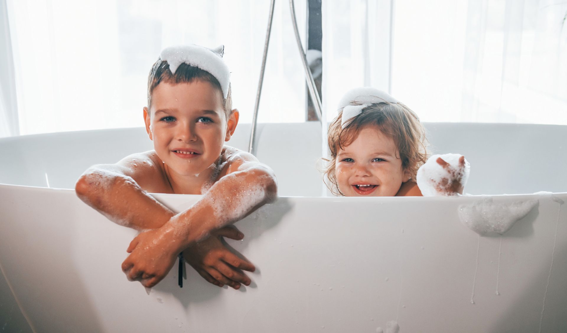 A boy and a girl are taking a bath together.