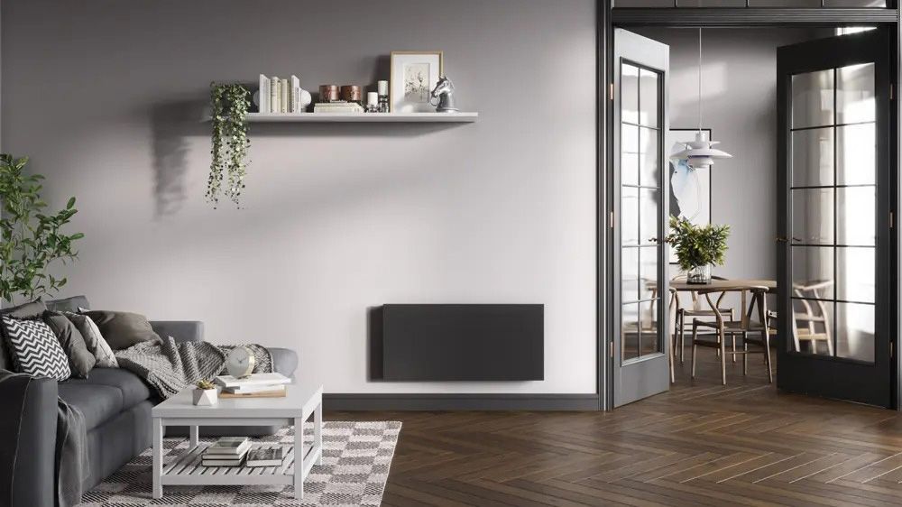 A living room with a couch , coffee table , and a radiator on the wall.