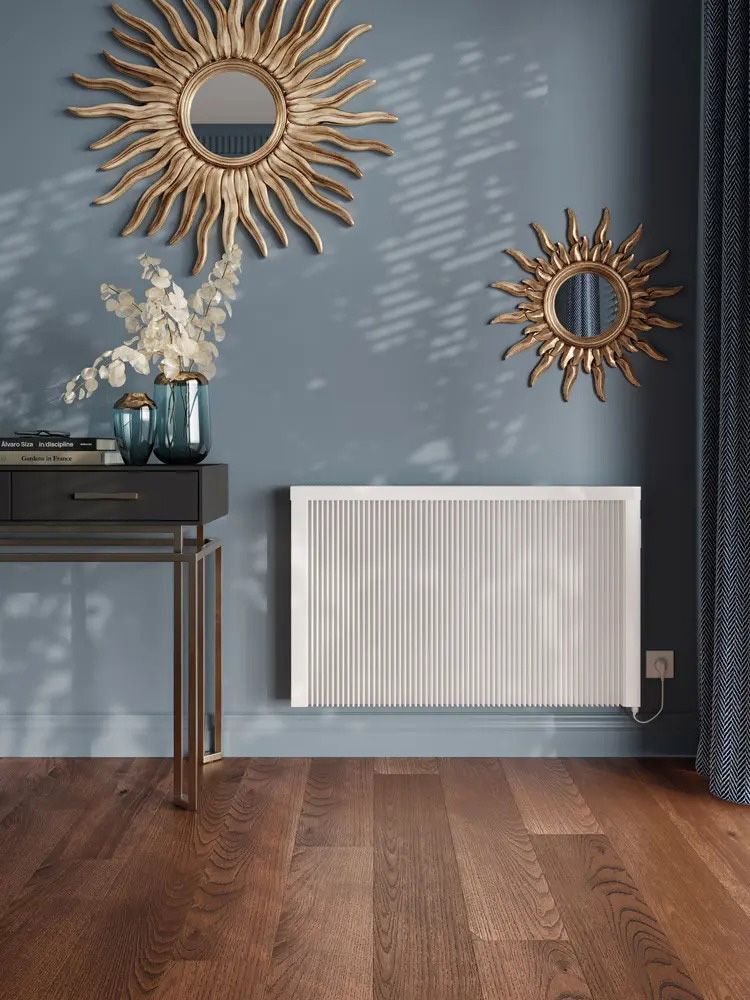 A living room with a white radiator and two mirrors on the wall.