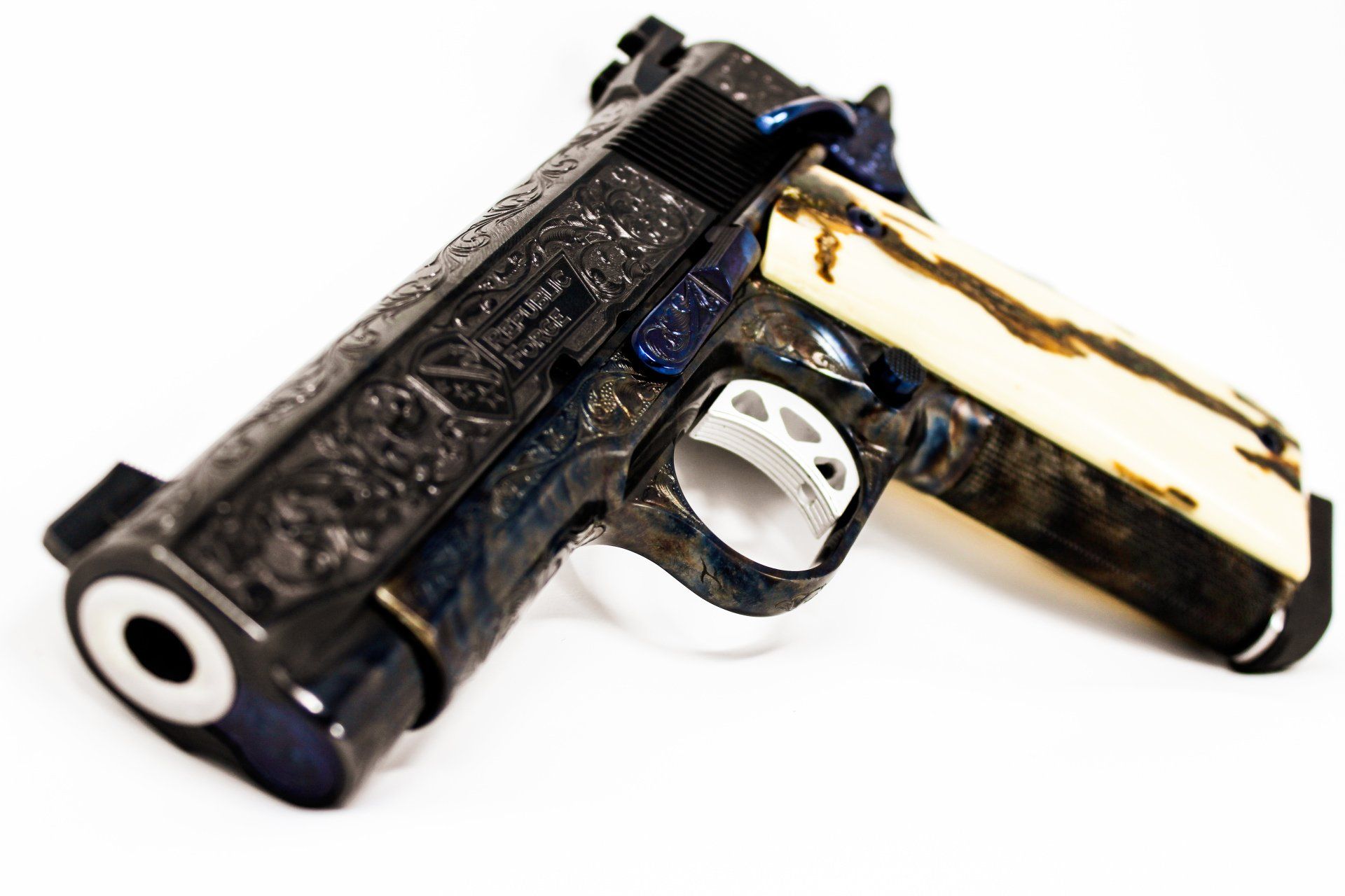 Customized handgun with elaborate engraving, blue highlights, and bone-colored grips on a white background.