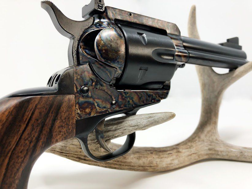 Close-up of a revolver with wooden grip resting on a deer antler.