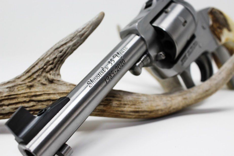 Silver revolver with antler, text reads 