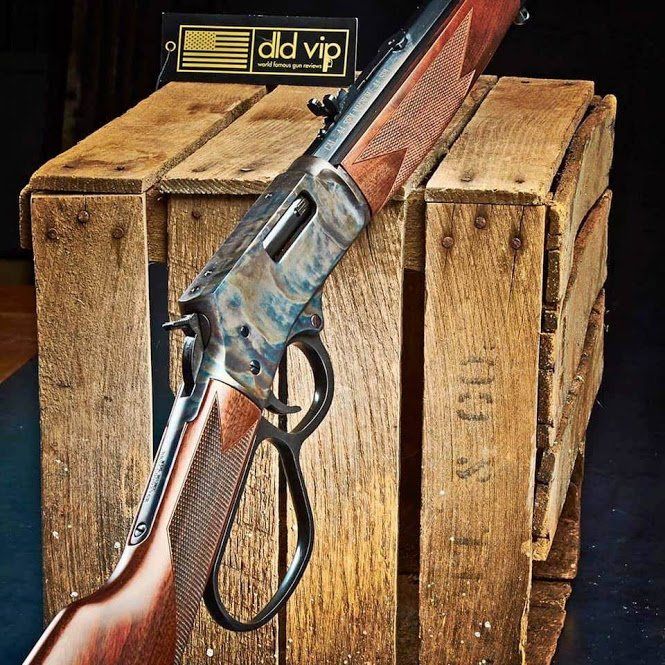 Lever-action rifle on wooden crate, featuring dark metal and patterned wood.