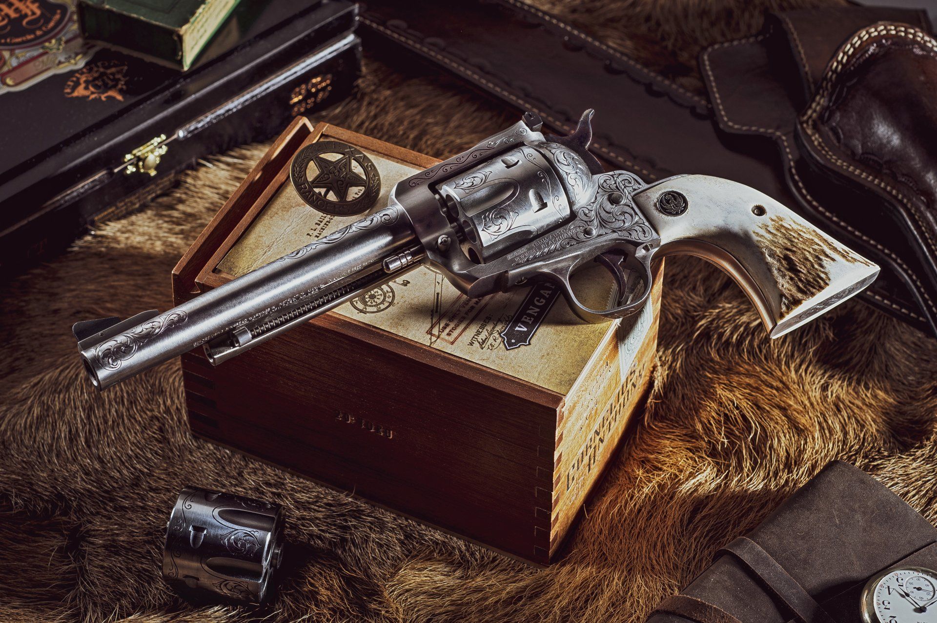 Revolver pistol rests on a box, surrounded by accessories on a fur surface.