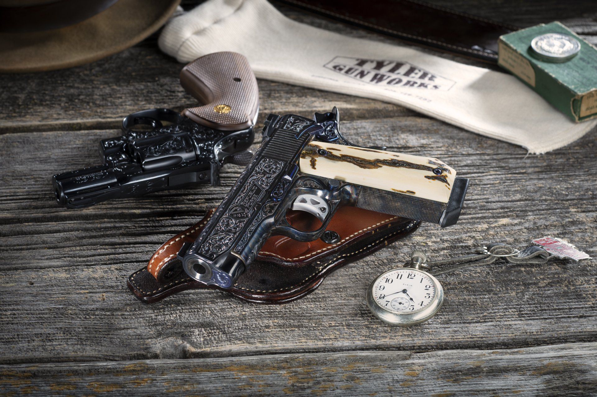 Two ornate pistols, a holster, pocket watch, and other items on a weathered wooden surface.