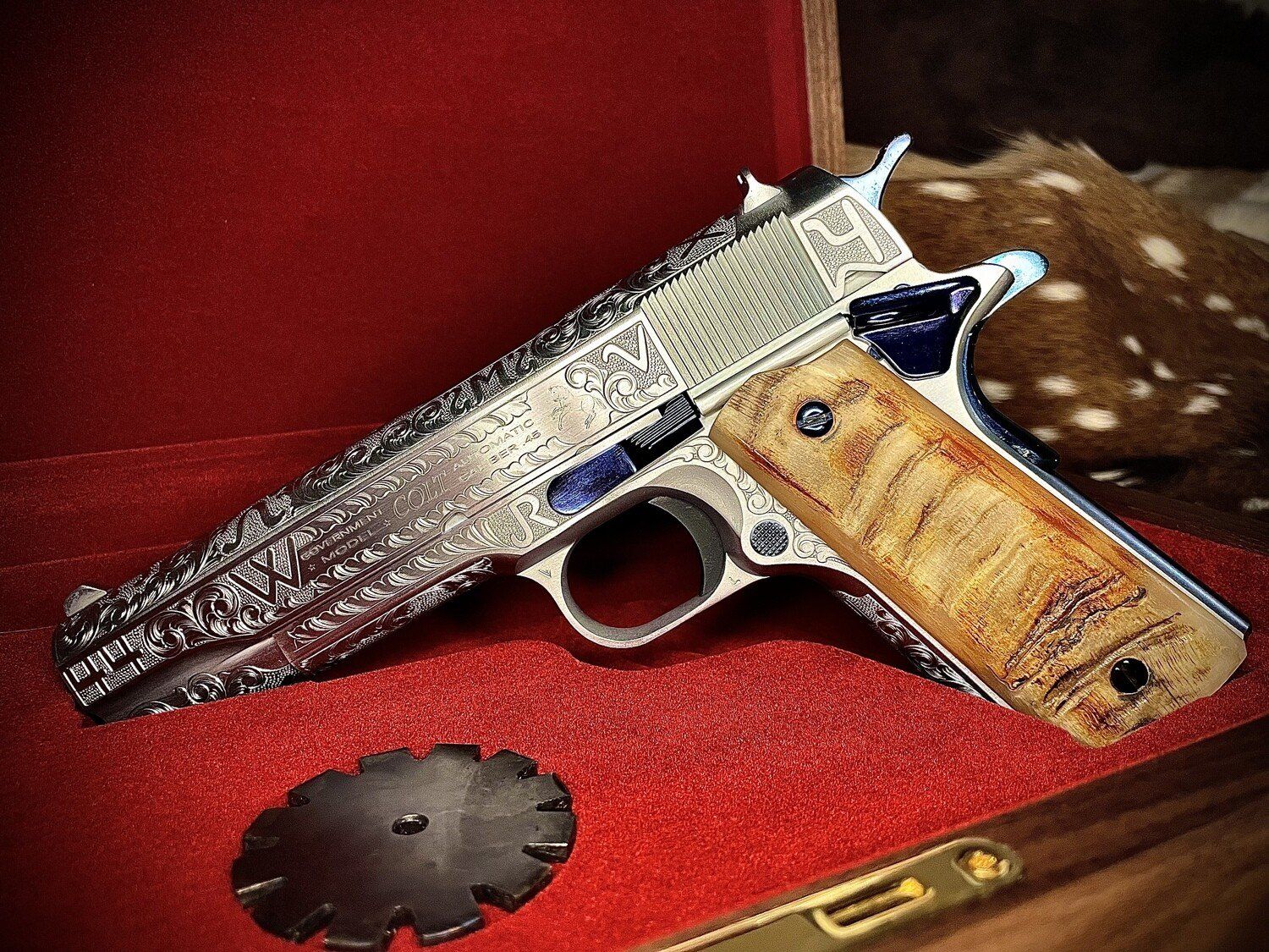 Detailed silver pistol in a wooden case with a red interior. The handle is wooden, with a matching silver gear at the bottom.