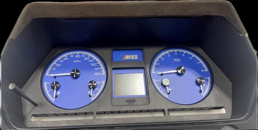 Car dashboard with blue gauges and a digital display.