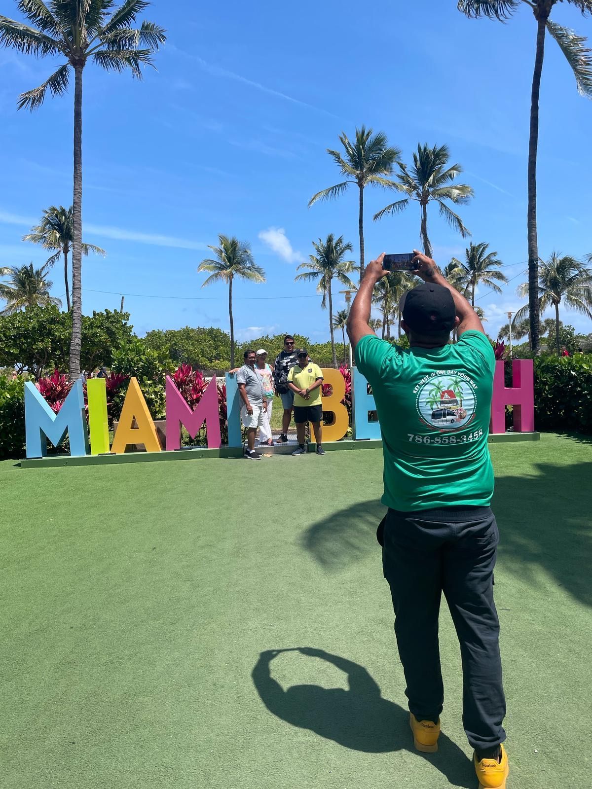 Tour guide capturing guest photo at the Miami Beach stop during a Miami City Tour with small group service
