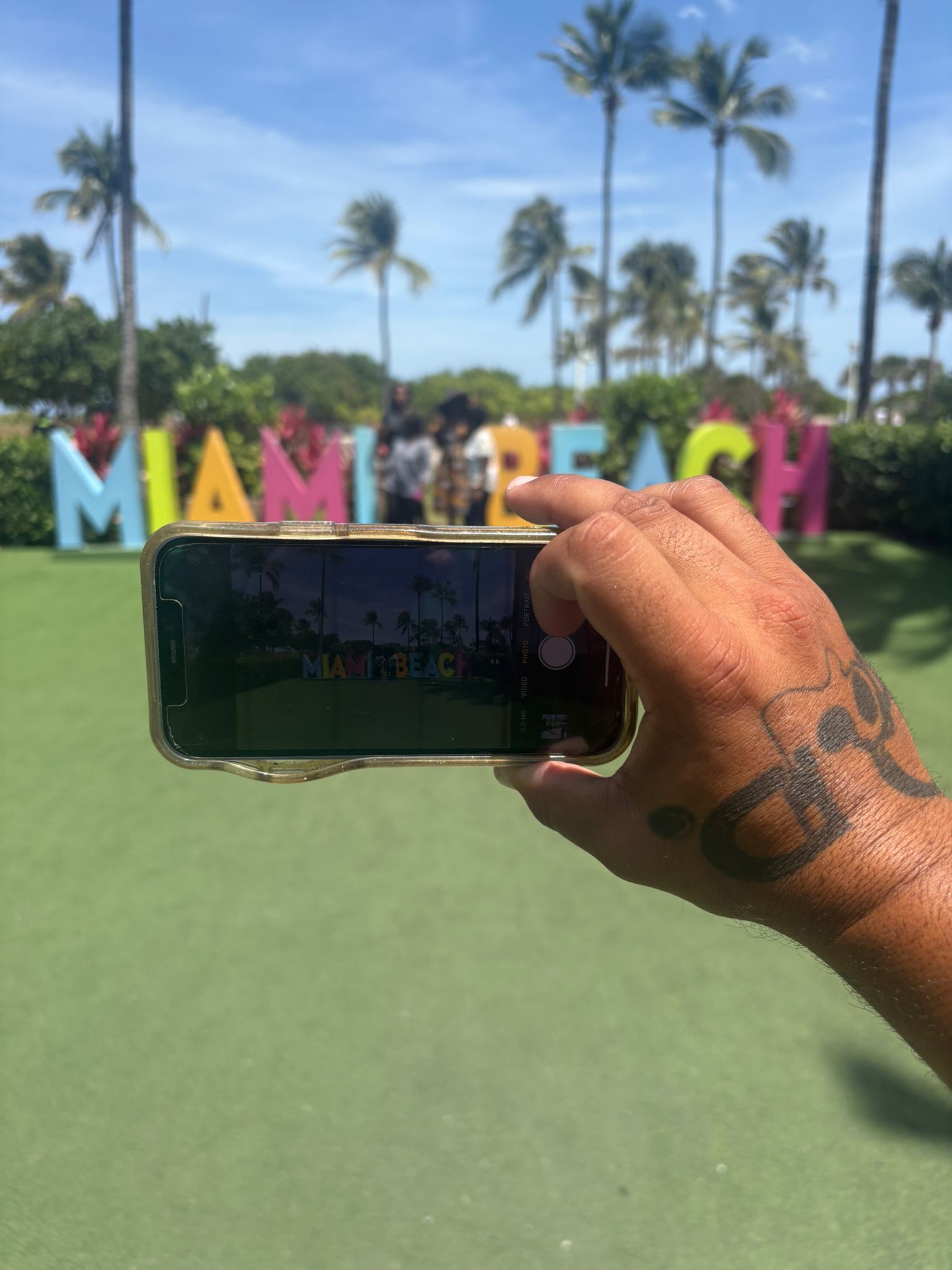Guest capturing the iconic Miami Beach sign during a stop on the Hop on Hop off Miami City Tour
