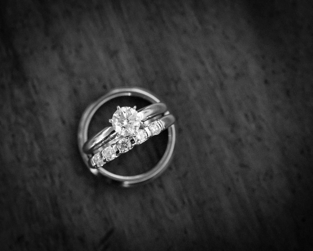 Three Silver Rings With Diamonds, Stacked on a Textured, Dark Surface — Regency Jewellers in Cairns City, QLD