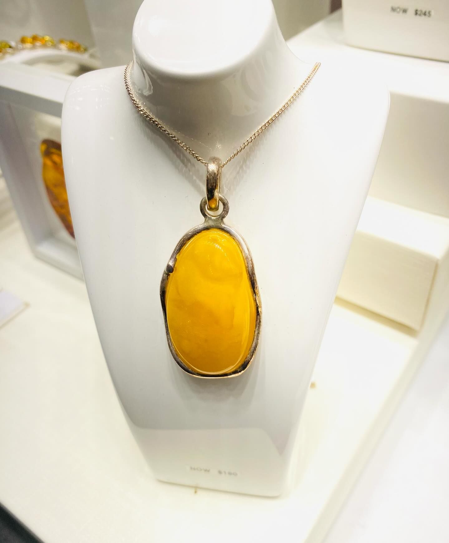 Yellow Amber Pendant Necklace on a White Display Stand — Regency Jewellers in Cairns City, QLD