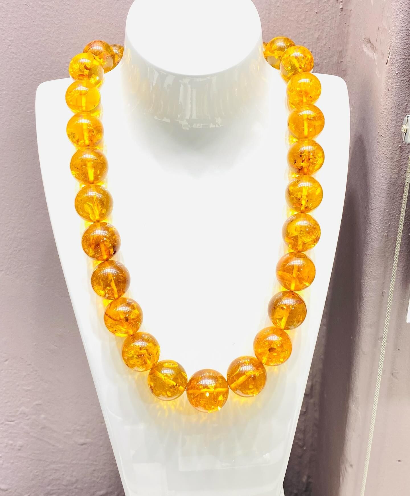 Amber Bead Necklace Displayed on a White Bust Against a Pinkish Background — Regency Jewellers in Cairns City, QLD