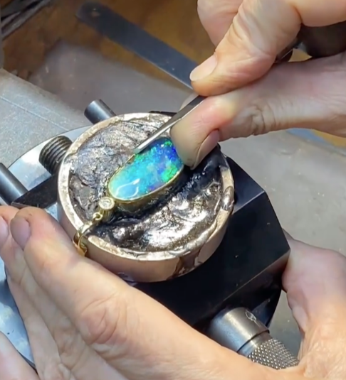 Hands Using a Rotary Tool to Polish a Gold Ring With a Purple Gemstone — Regency Jewellers in Cairns City, QLD