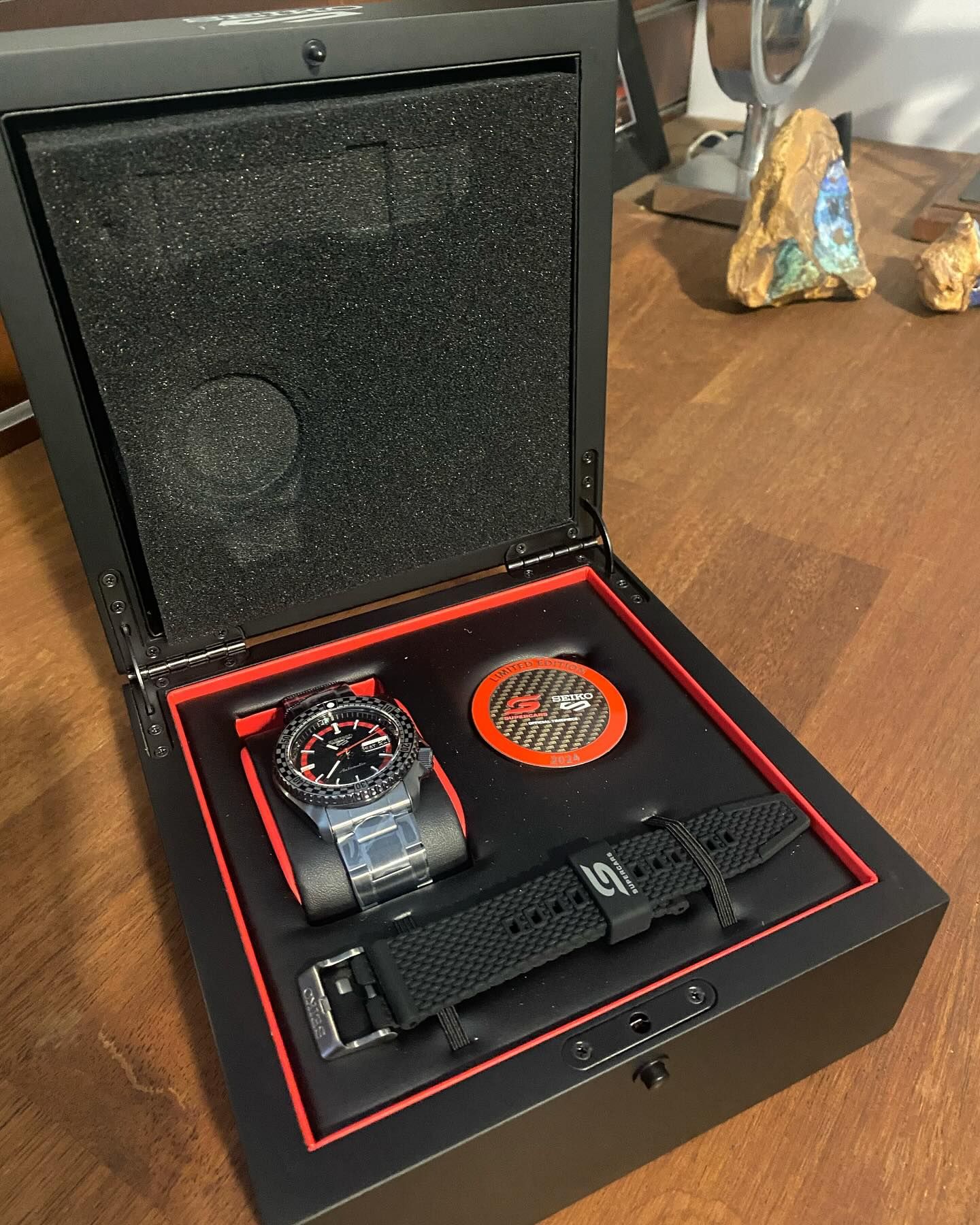 Open Watch Box With a Wristwatch, Extra Band, and a Circular Item — Regency Jewellers in Cairns City, QLD