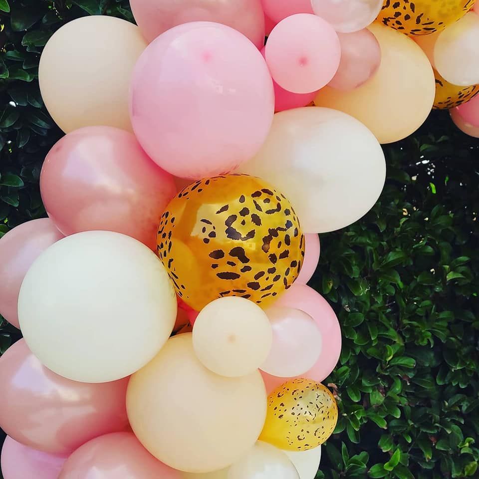 Un mazzo di palloncini rosa, bianchi e gialli con stampa leopardata