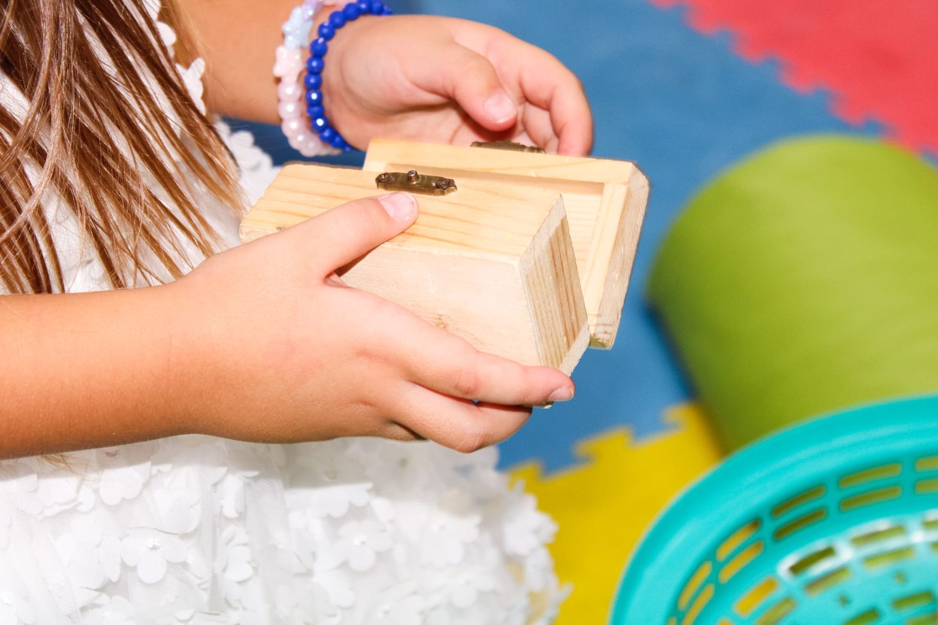 Una bambina tiene in mano un pezzo di legno.