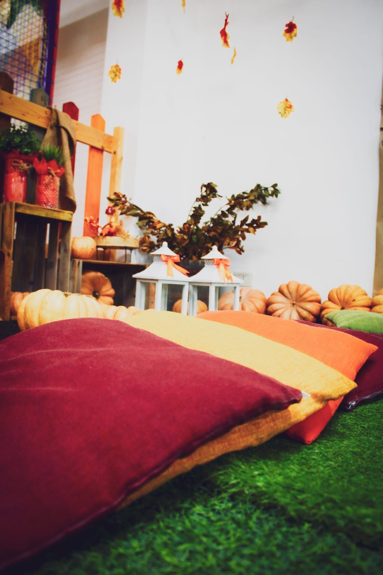 Una stanza con un sacco di cuscini e zucche sul pavimento