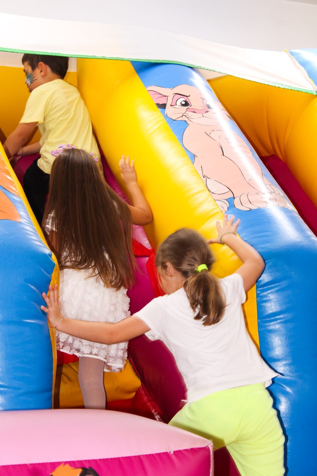 I bambini stanno giocando su uno scivolo gonfiabile con un cane sopra
