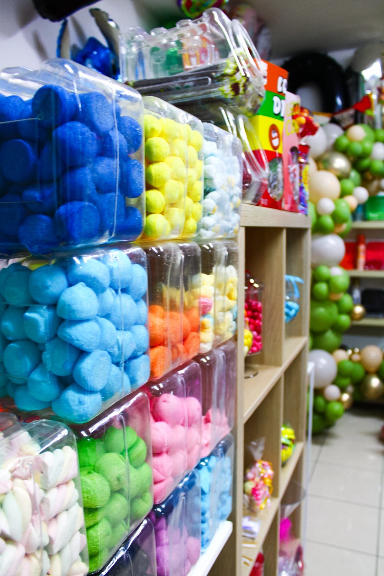 Un negozio pieno di caramelle colorate e palloncini.