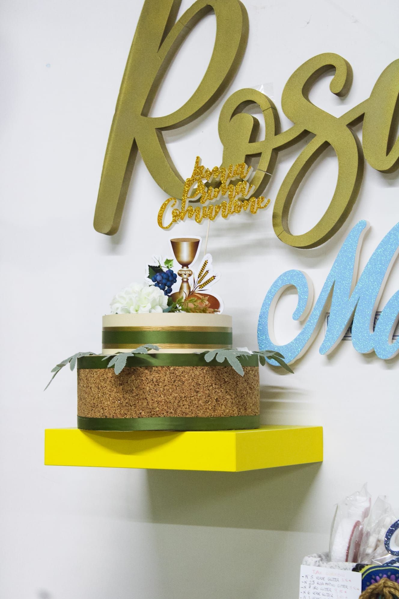 Una torta è appoggiata su uno scaffale giallo davanti a una parete con la parola rosa sopra.