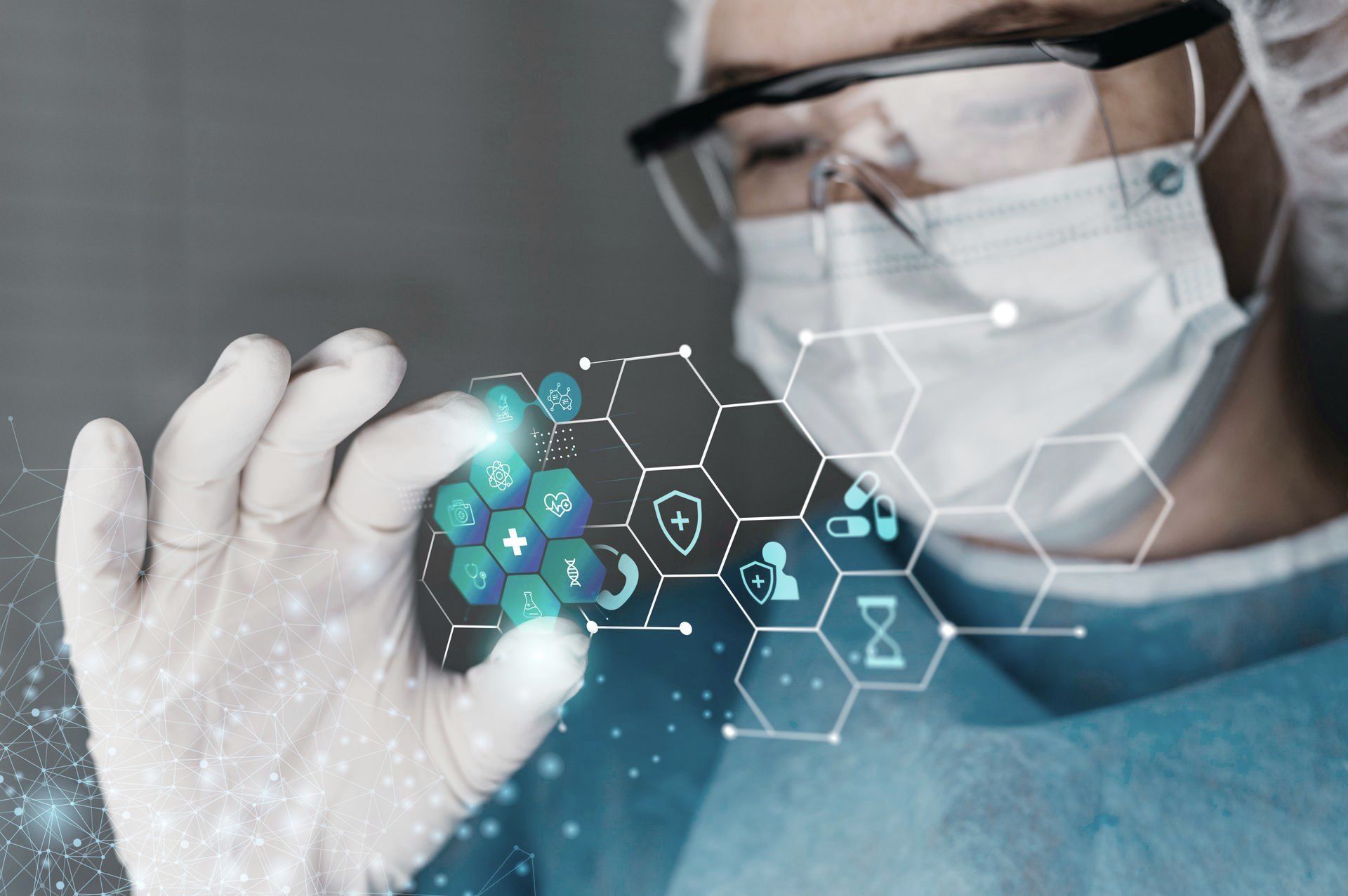 A surgeon wearing a mask and goggles is touching a screen