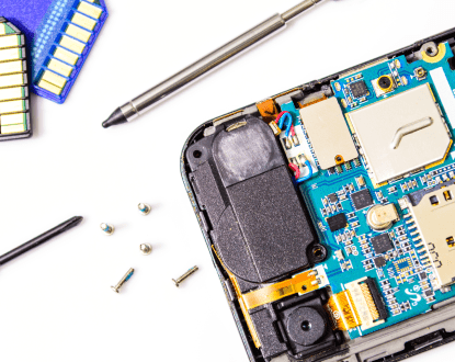 The inside of a cell phone is being repaired with a screwdriver.