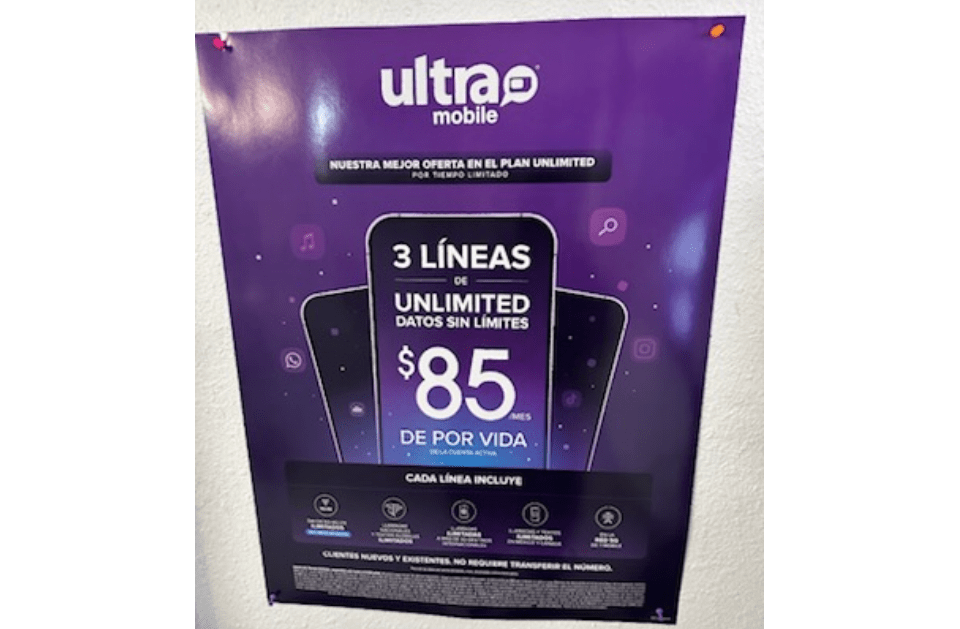 A purple poster for ultra mobile is hanging on a wall.