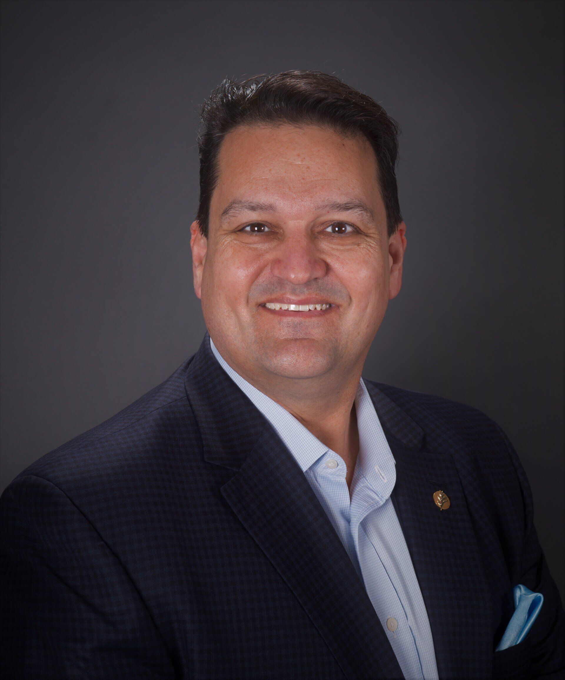 A man in a suit and tie is smiling for the camera.